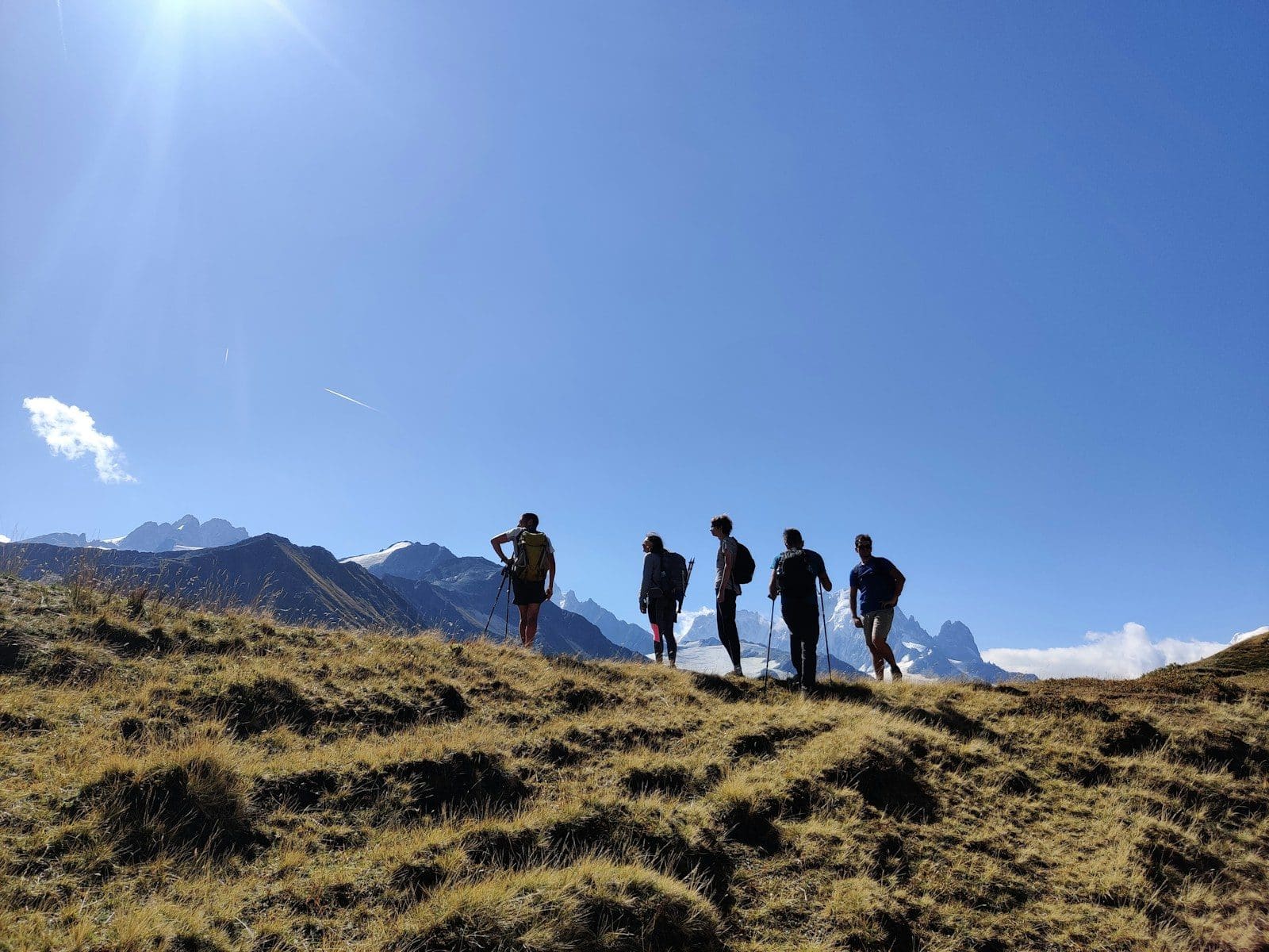 Confort en randonnée a group of people standing on top of a grass covered hillside